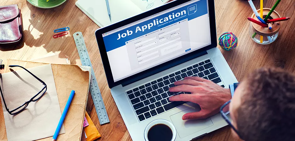 User accessing an online job application on a laptop computer